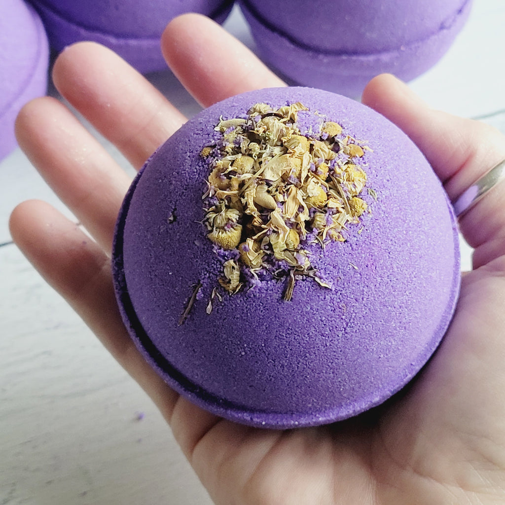 large lavender bath bomb with chamomile flowers on top
