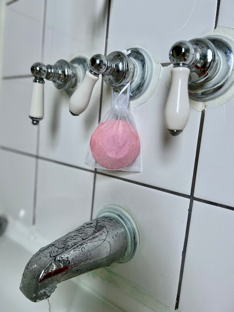 shower steamer grapefruit lime hanging on bath faucet
