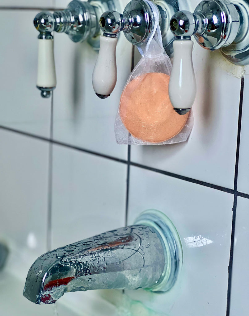 clarity shower soother hanging on bath faucet orange
