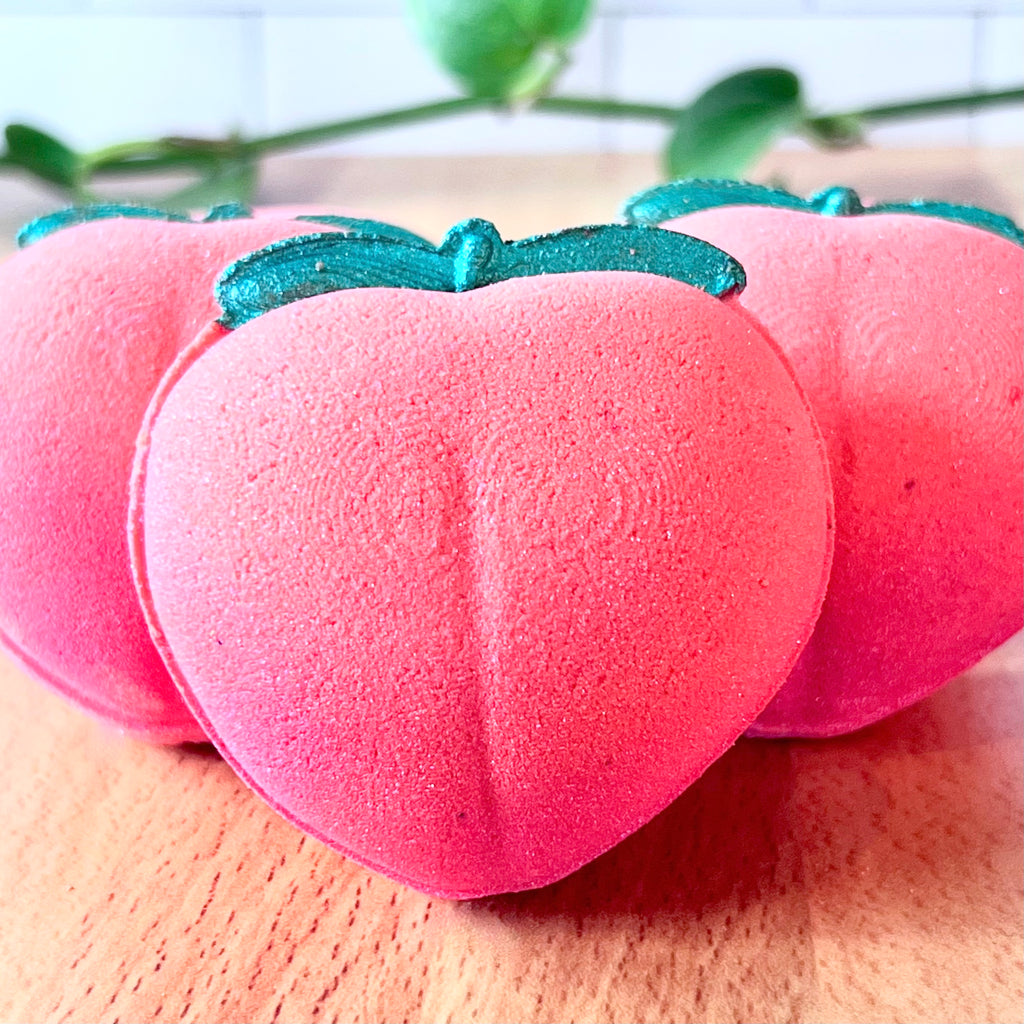 gradient pink to peach bath bomb with green leaves